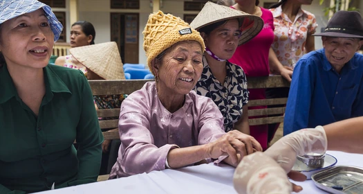 Patients receiving treatment in a health camp in Asia Patients getting screened in a community health camp in Vietnam